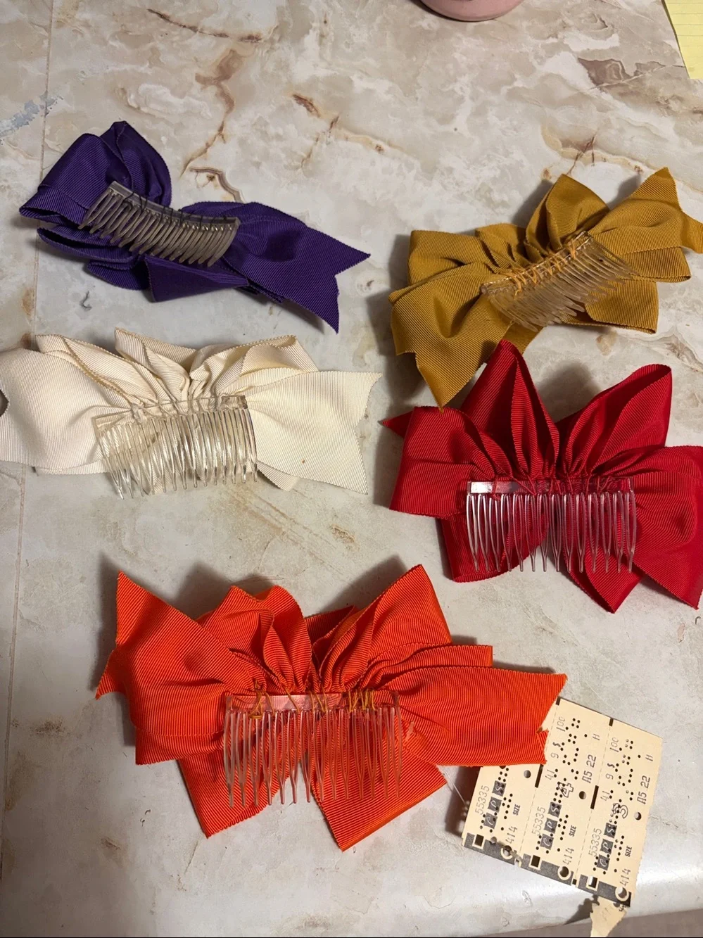Vintage ribbon hair bows in purple, gold, cream, orange, and red.